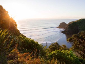 An aerial view of sea and the hill, with sunset at the horizon.